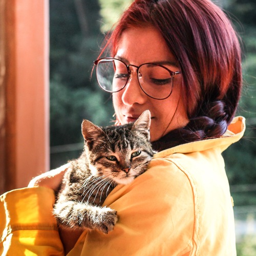 Woman in a yellow raincoat holding the cutest kitty cat